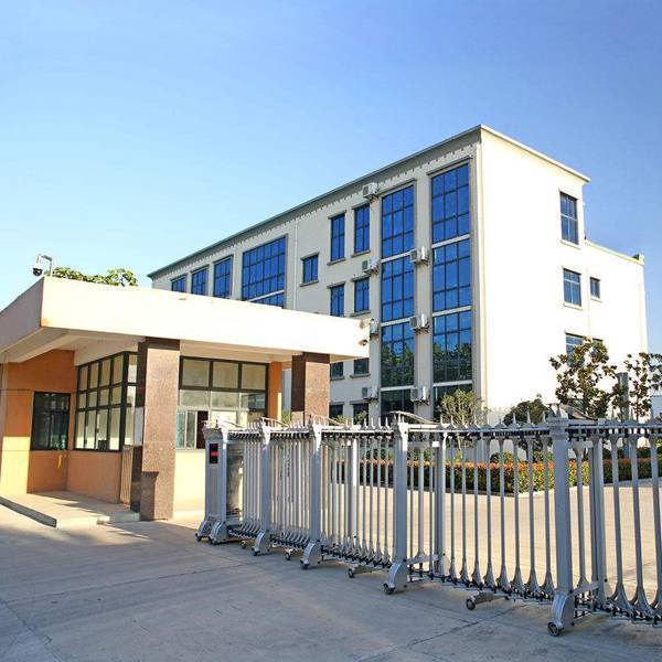 There are some green trees and other green plant around the office building.