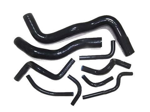 Several different shapes of black silicone elbows on white background.