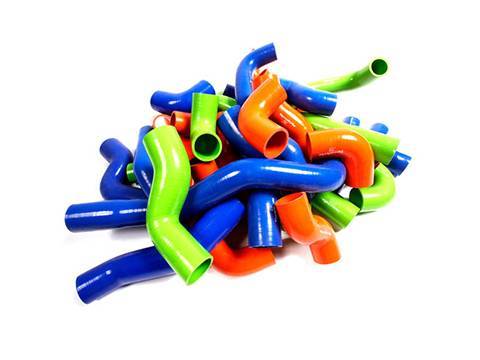 Several different colors of silicone elbows on white background.