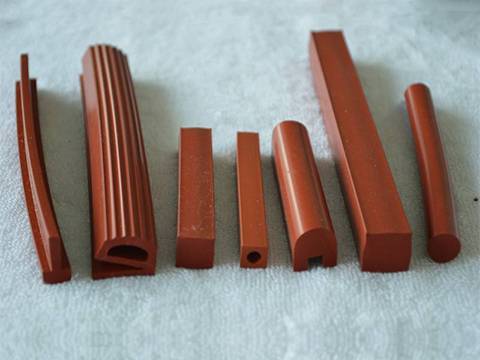 Seven red color silicone strip on a to white towel in different shapes.